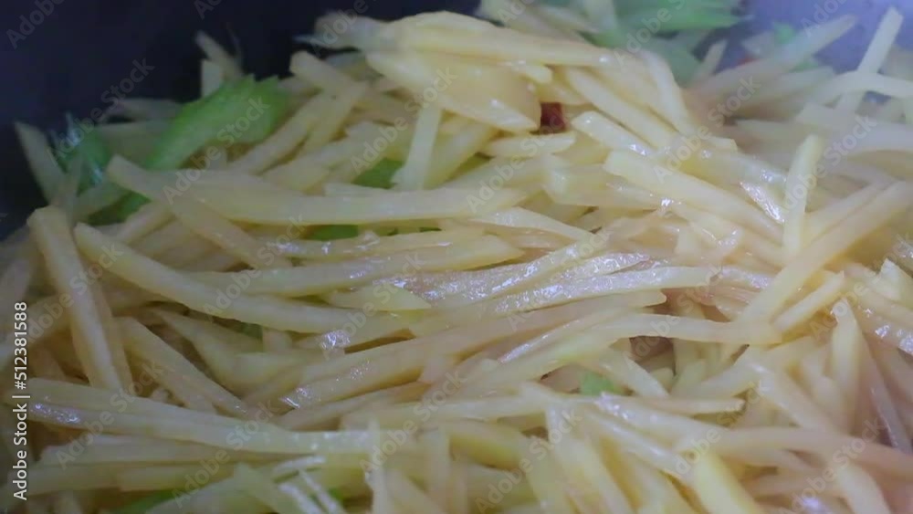 close up spatula stir frying shredded potatoes in wok. super slow motion close up spatula stir frying shredded potatoes in wok. super slow motion