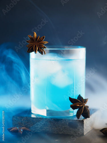 Alcoholic cocktail with blue liqueur, sambuca and anise. Smoky background photo