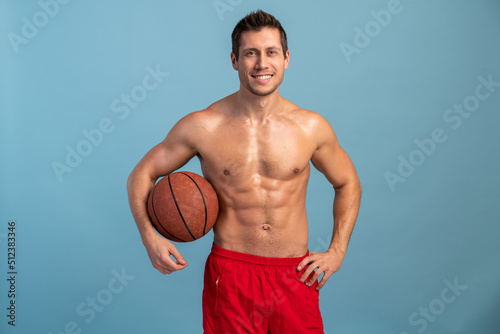Cool well shaped modern man posing with basketball ball. Body care, healthcare, weight loss, pride, strength, leadership, motivation, happiness, authority, gym concept
