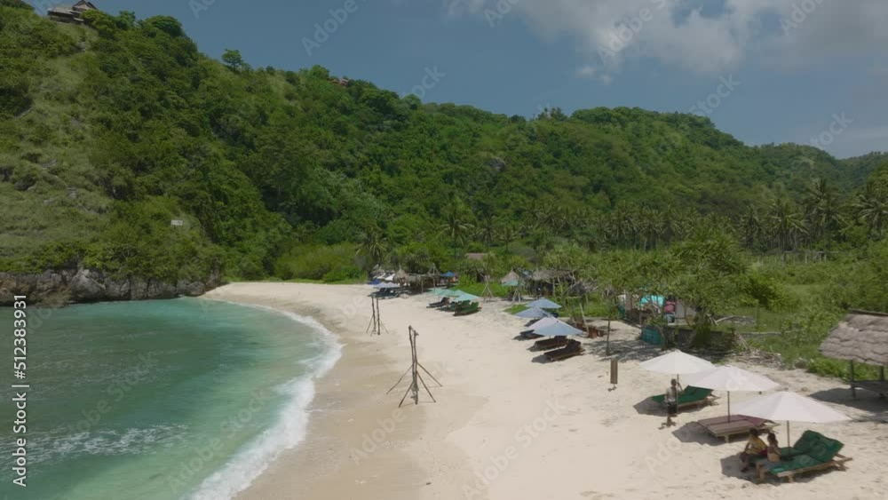 Touristic destination on Nusa Penida, white sand Atuh Beach with lounge beds and umbrellas Touristic destination on Nusa Penida, white sand Atuh Beach with lounge beds and umbrellas