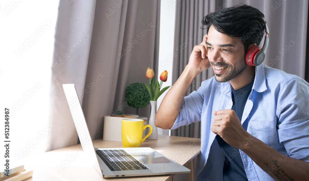 Joyful indian guy in casual with wireless headset sitting at workdesk in front of modern laptop, singing karaoke, relaxing while working at office, copy space. Stress relief at job concept Joyful indian guy in casual with wireless headset sitting at workdesk in front of modern laptop, singing karaoke, relaxing while working at office, copy space. Stress relief at job concept