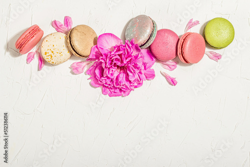 Macarons with peony flower on a stone background. Sweet dessert, colorful and pastel colors