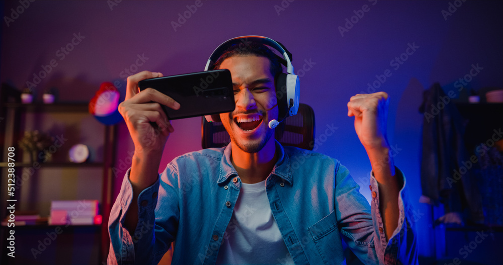 Premium Photo  Asian man playing game on mobile phone professional gamer  playing video games on personal pc computer colorful neon light room esport online  game