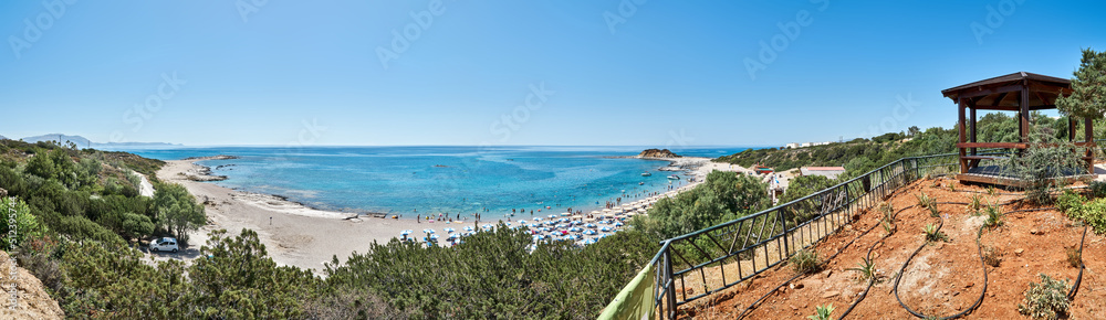 Sea bay beach near resort hotel on island Rhodes in Greece panorama. Ground with drip irrigation on hill against turquoise water and blue sky