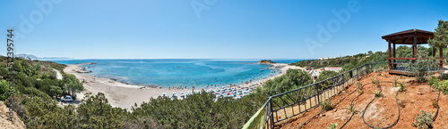 Sea bay beach near resort hotel on island Rhodes in Greece panorama. Ground with drip irrigation on hill against turquoise water and blue sky