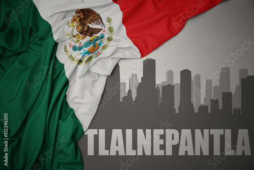 abstract silhouette of the city with text Tlalnepantla near waving colorful national flag of mexico on a gray background. photo