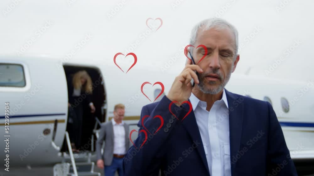Animation of heart icons over caucasian businessman using smartphone Animation of heart icons over caucasian businessman using smartphone