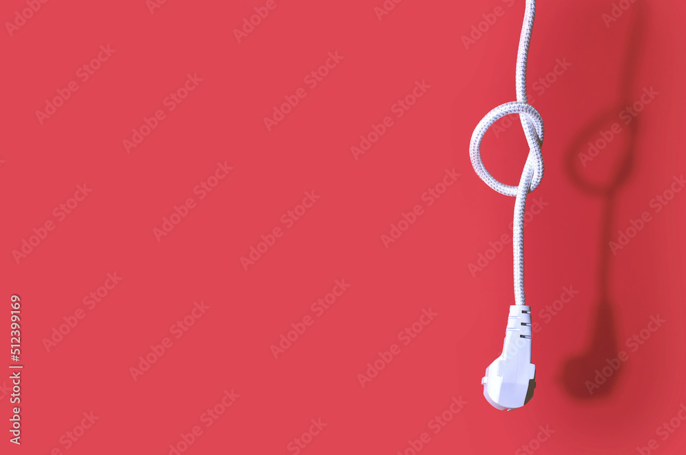Electric plug for a socket with a knot on a cable on a red background with free space for text. The concept of the inability to get energy or electricity. No access to electricity or power outage Electric plug for a socket with a knot on a cable on a red background with free space for text. The concept of the inability to get energy or electricity. No access to electricity or power outage