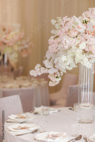 festive wedding decoration. Beautiful fresh white and pink flowers in glass vase on dining table on wedding day. High quality photo © Andriy Medvediuk