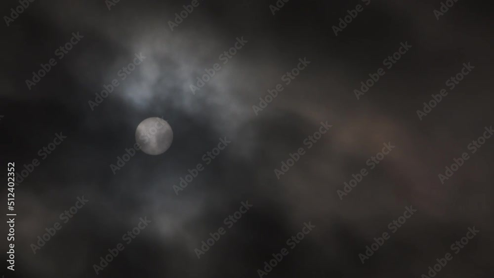 Eerie dark and stormy sky with bright orb, sun or moon, shining bright as thick clouds pass.