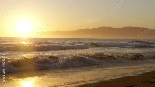 Raging ocean with golden sunset background in Los Angeles
