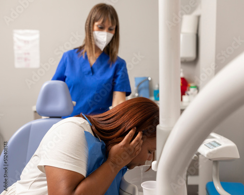 A black woman patient is spitting out at the dental clinic photo