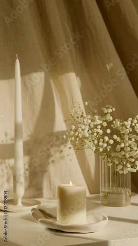 Still life with burning candles, a bouquet of wildflowers, linen fabric on the background and sunlight