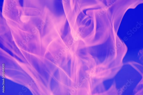 Abstract glare of flames of pink light on a blue background.
