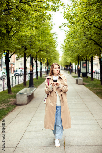 young beautiful female traveler uses a smartphone in a foreign city to find a way, a hotel photo