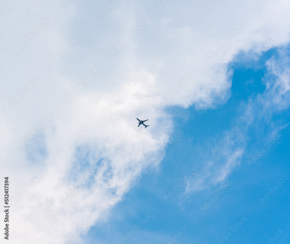 Airplane flying in the sky with white clouds