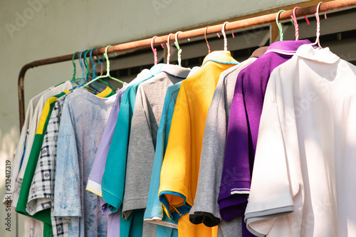 Colorful adult male clothes hanging on old clothes line with sunlight
