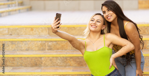 Two young women taking a selfie with their smartphone
