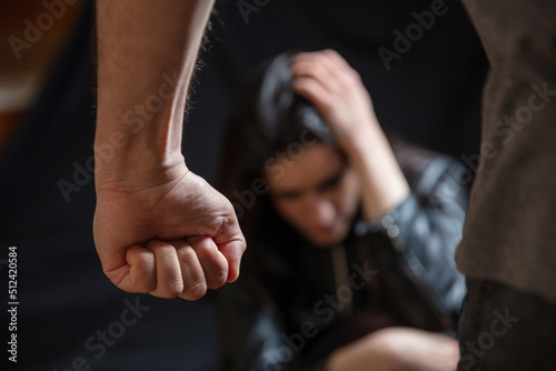 Woman abuse, Young woman scared, male clenched fist close up. Domestic violence photo