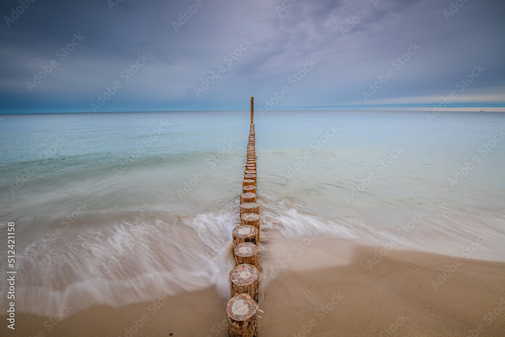 Amazing sunrise over the beach in Chalupy. Seascape with breakwater