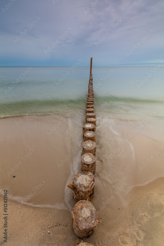 Amazing sunrise over the beach in Chalupy. Seascape with breakwater