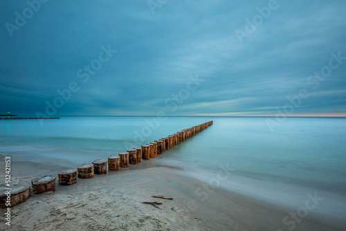 Amazing sunrise over the beach in Chalupy. Seascape with breakwater