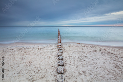 Amazing sunrise over the beach in Chalupy. Seascape with breakwater