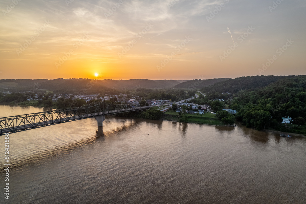 Sunset Over a River and Bridge next to Small Town