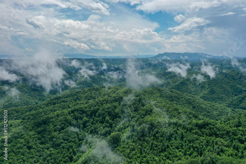 Misty Clouds Over Green Mountains with Blue Sky © gregmrotek