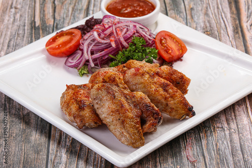 Grilled chicken wings served onion