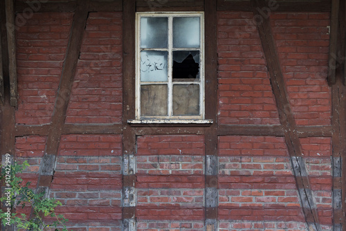 Verfallenes Haus mit kaputtem Fenster und altem Tor
