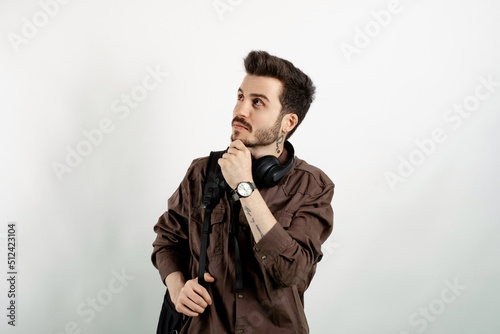 Portrait of casual young man wearing casual clothes posing isolated over white background serious face thinking about question, very confused idea