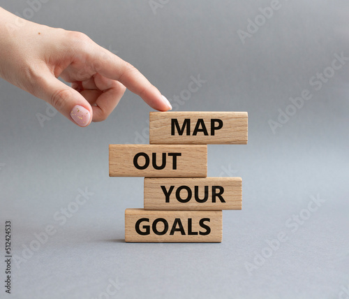 Goals symbol. Wooden blocks with words Map out your goals. Beautiful grey background. Businessman hand. Business and 'Map out your goals' concept. Copy space.