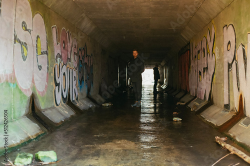 Men in a graffiti Waterway tunnel