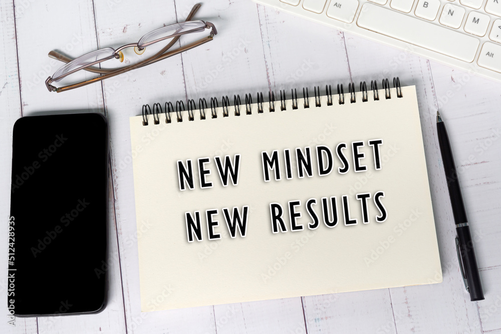 New mindset, new results text on notepad on white wooden desk. New mindset, new results text on notepad on white wooden desk.
