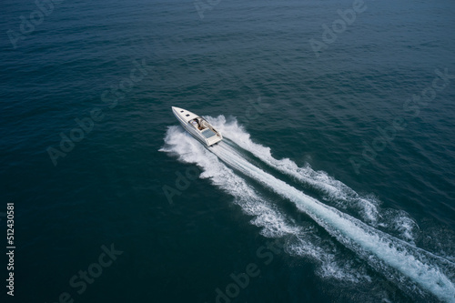 Large high speed open motorboat moving diagonally aerial view. White boat in motion side view. Mega boat moves fast on the water. © Berg