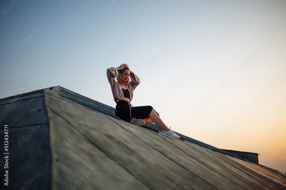 Young woman posing in the roof at sunset, freedom city atmosphere. People, lifestyle, relaxation concept. Young woman posing in the roof at sunset, freedom city atmosphere. People, lifestyle, relaxation concept.