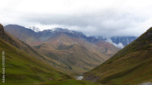 Incredibly beautiful Caucasian landscapes and a mountain river. View of the river valley and snowy mountains from above.