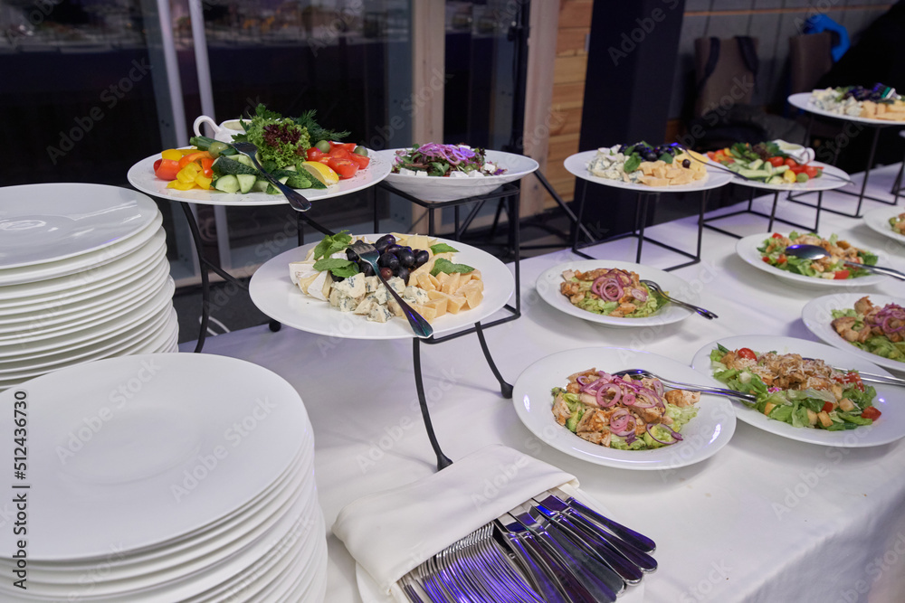Table with fresh salads in plates at a banquet is waiting for its guests