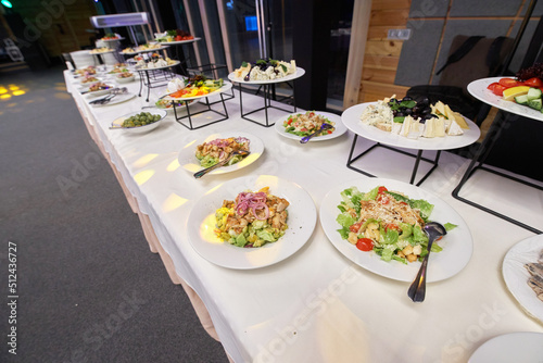 Table with fresh salads in plates at a banquet is waiting for its guests