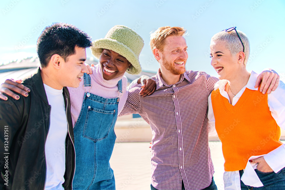 Group of four friends laughing out loud outdoor. Two couples talking and enjoying a good day