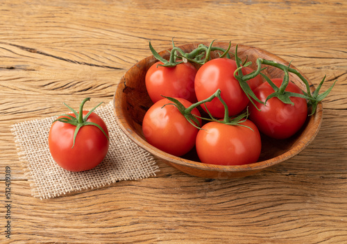 Foto Red tomatoes in a bowl over wooden table