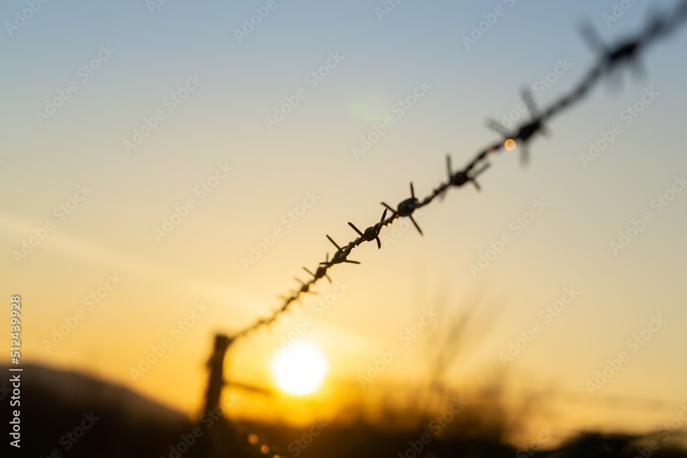 Barbed wire on the fence during sunset colorful sky. Slovakia Barbed wire on the fence during sunset colorful sky. Slovakia