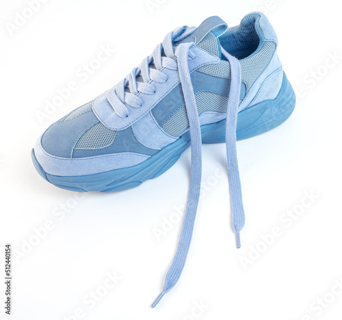 One unlaced light blue sneaker on a white background. Sports shoes photo