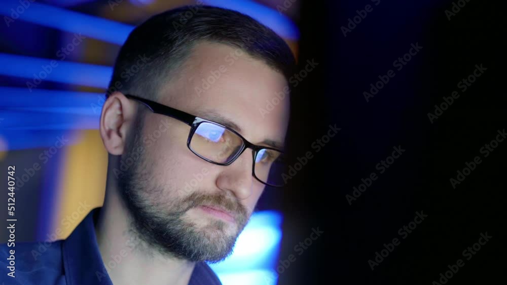 Close-up of a concentrated man in glasses who works at a computer. Close-up of a concentrated man in glasses who works at a computer.