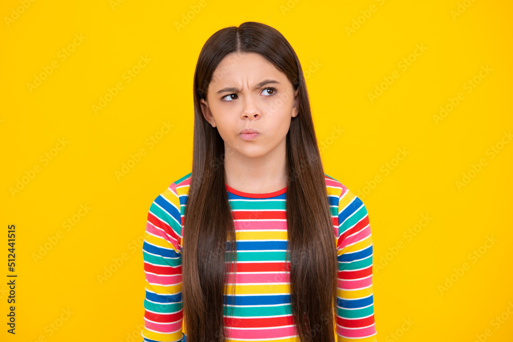 Angry face, upset emotions of teenager girl. Thoughtful teenager child thinking, pensive child making idea, posing isolated on yellow isolated background. Kid curious creative think. Angry face, upset emotions of teenager girl. Thoughtful teenager child thinking, pensive child making idea, posing isolated on yellow isolated background. Kid curious creative think.
