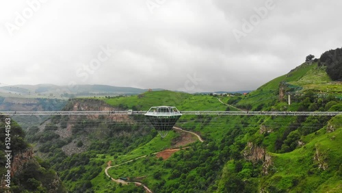 Dashbashi, Georgia - 19th june, 2022: Aerial fly over Diamond shape platform on glass bridge over scenic dashbashi valley in Georgia countryside. Famous modern bridge over valley in caucasus photo