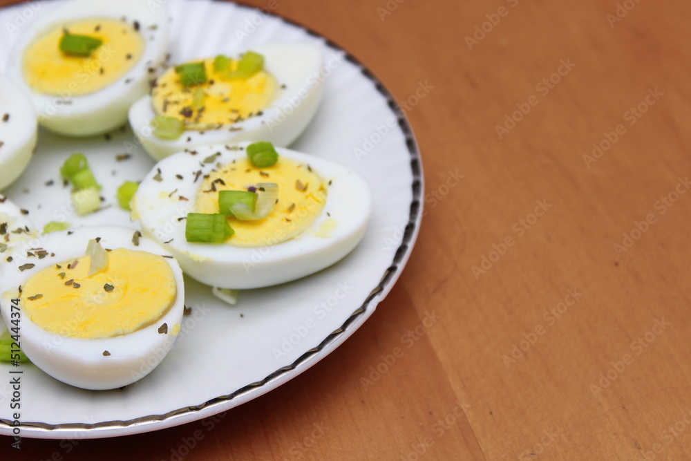 Half boiled eggs arranged in circles, garnished with sliced spring onions. In a white plate ready to serve. Half boiled eggs arranged in circles, garnished with sliced spring onions. In a white plate ready to serve.