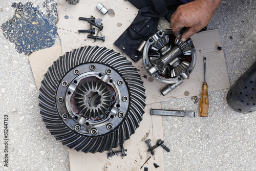 Close up on disassembling differential vehicle part during repair gear axle assembly photo
