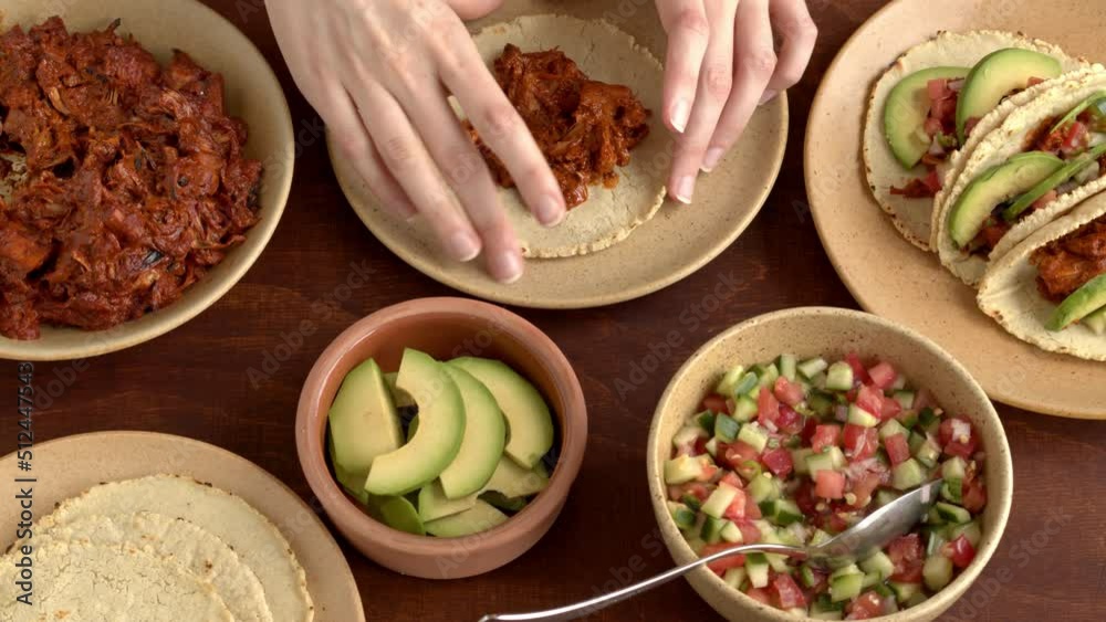 Female person preparing jackfruit tacos with avocado and pico de gallo salsa. Mexican vegan cuisine dish.
